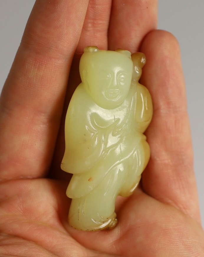 A rare Chinese yellow and russet jade figure of a boy holding a parrot, 18th/19th century, 5.6cm high, wood stand